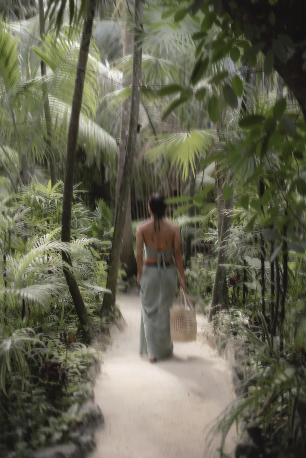 A woman walking through a lush tropical forest with a basket.