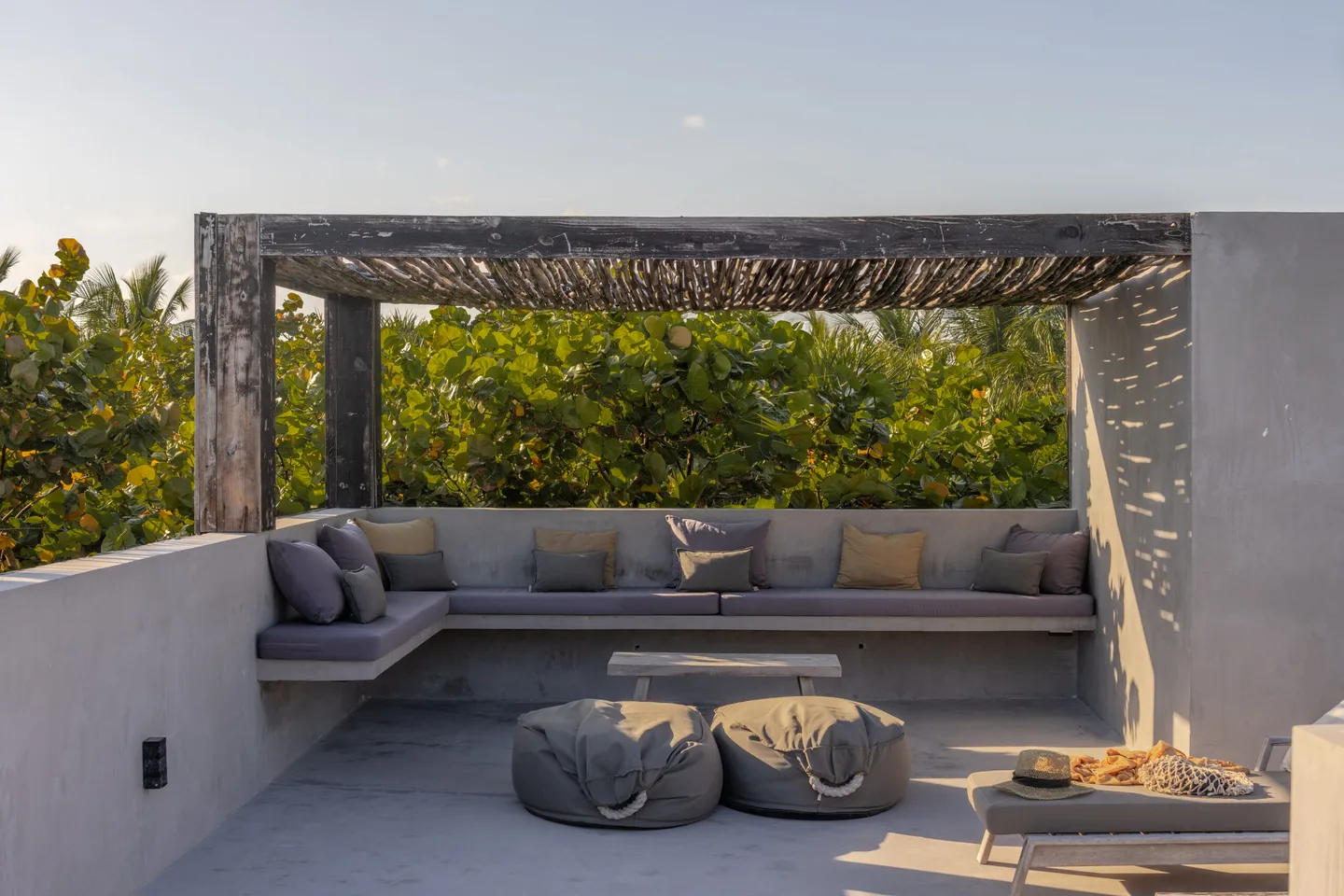 A rooftop terrace with built-in sofas and a pergola