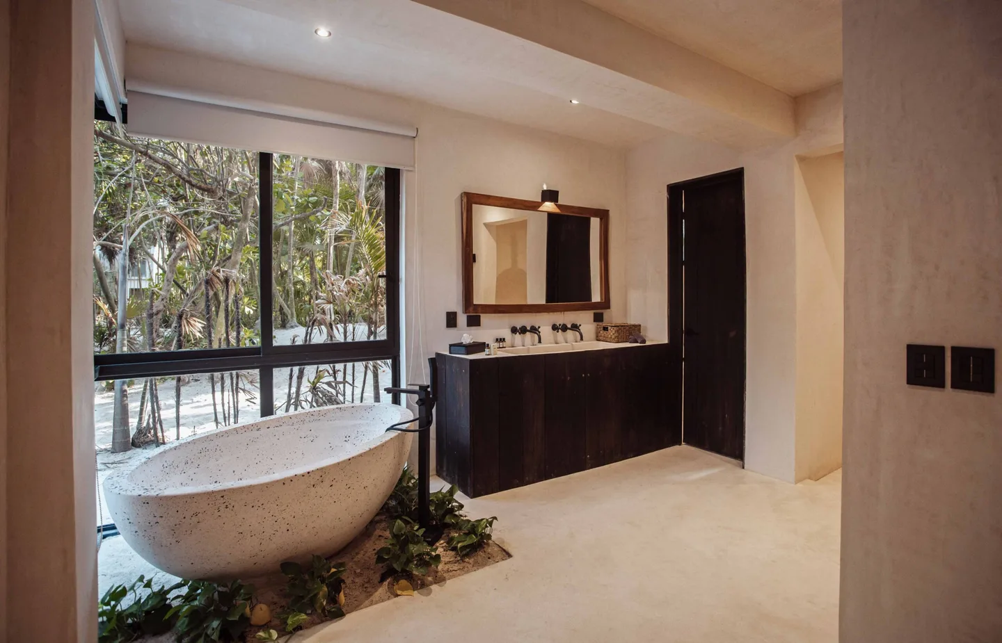Bathroom with a large bathtub and a window overlooking trees.